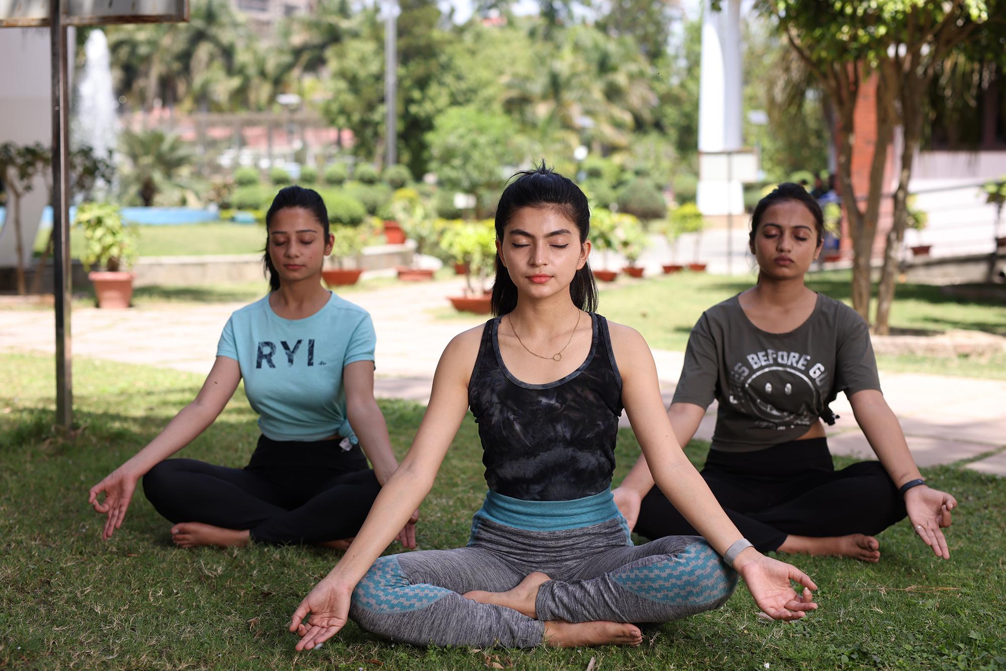 college student meditating or practicing yoga
