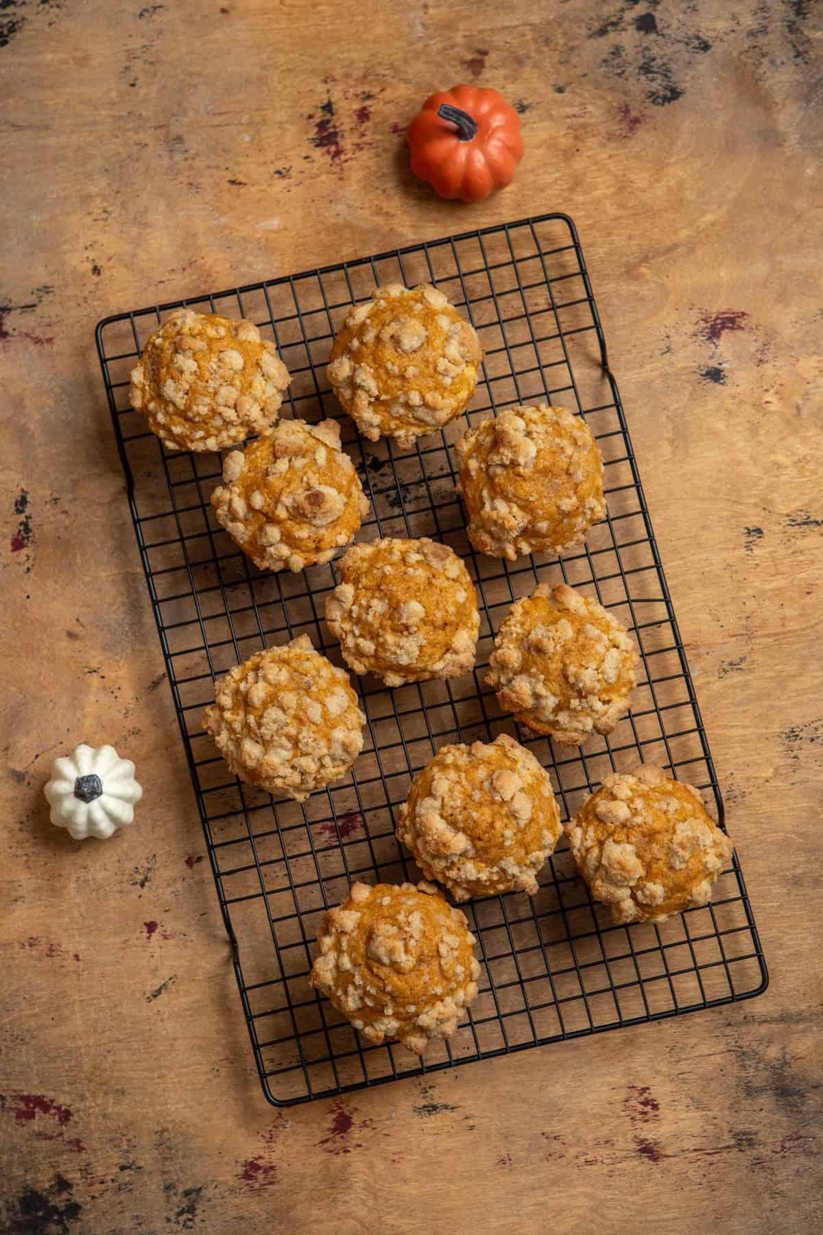 a batch of pumpkin streusel muffins cooling on a wire rack