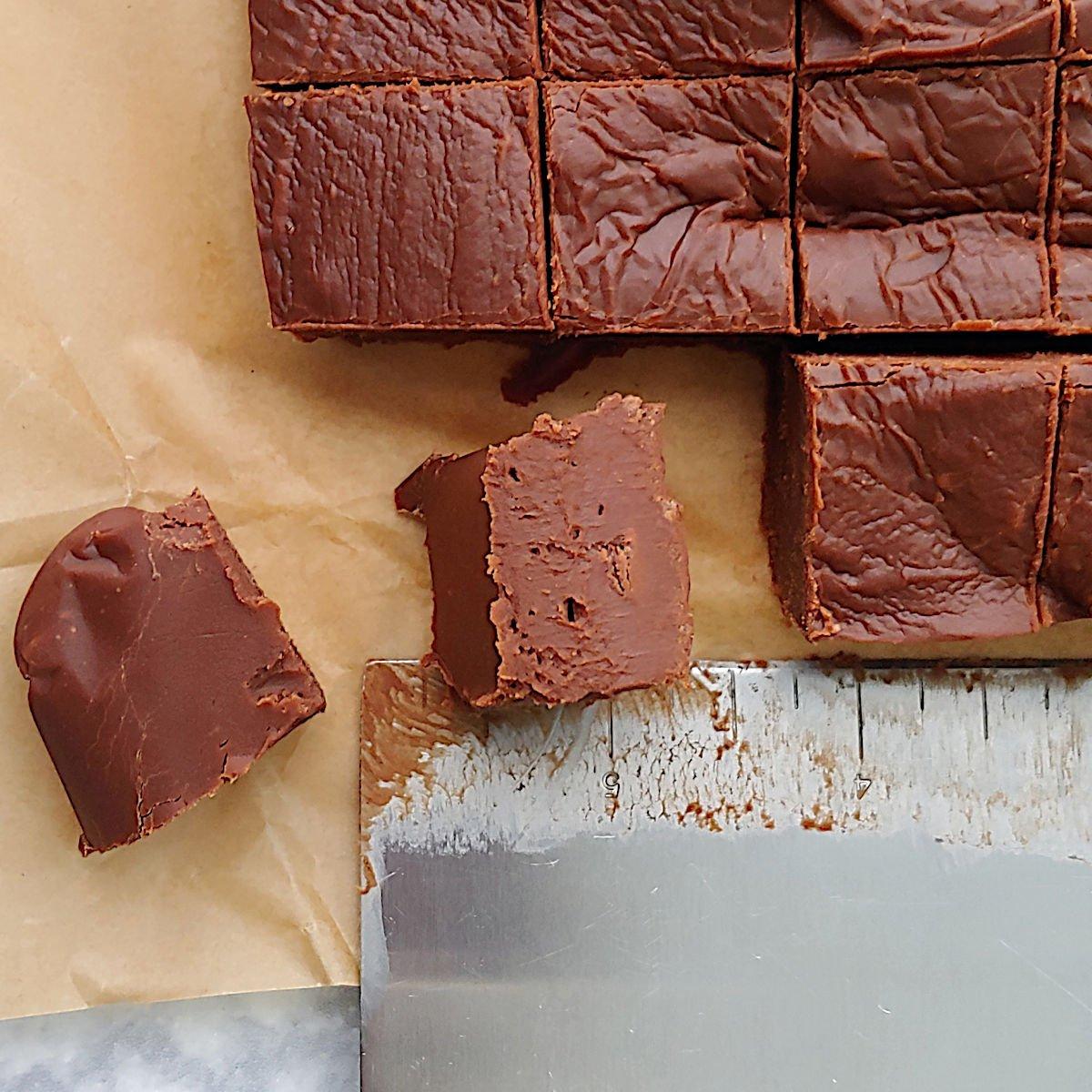 close-up of a hand cutting chocolate fudge into squares