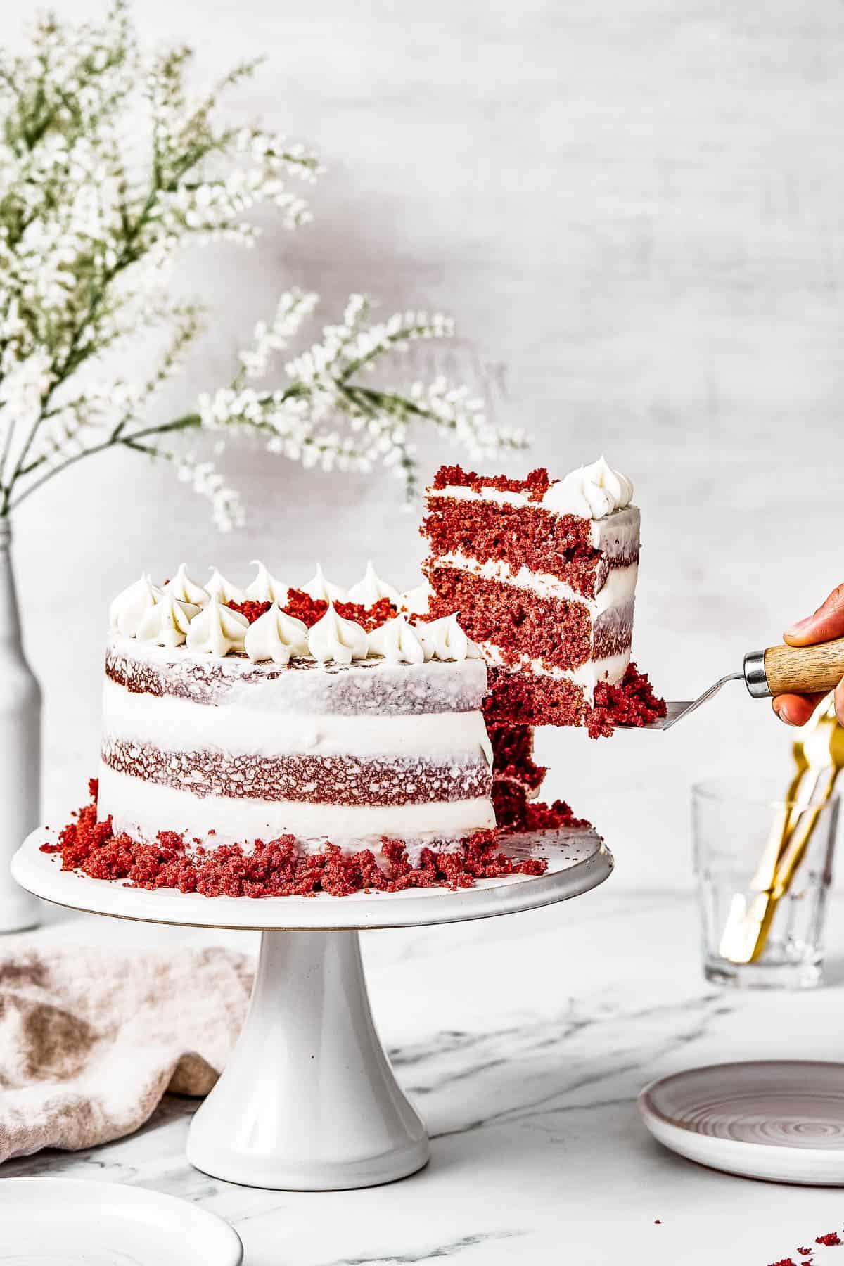 a whole crimson velvet cake on a cake stand with decorations