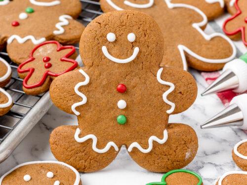 Homemade orange gingerbread cookies on a cooling rack with festive background, close-up, warm lighting
