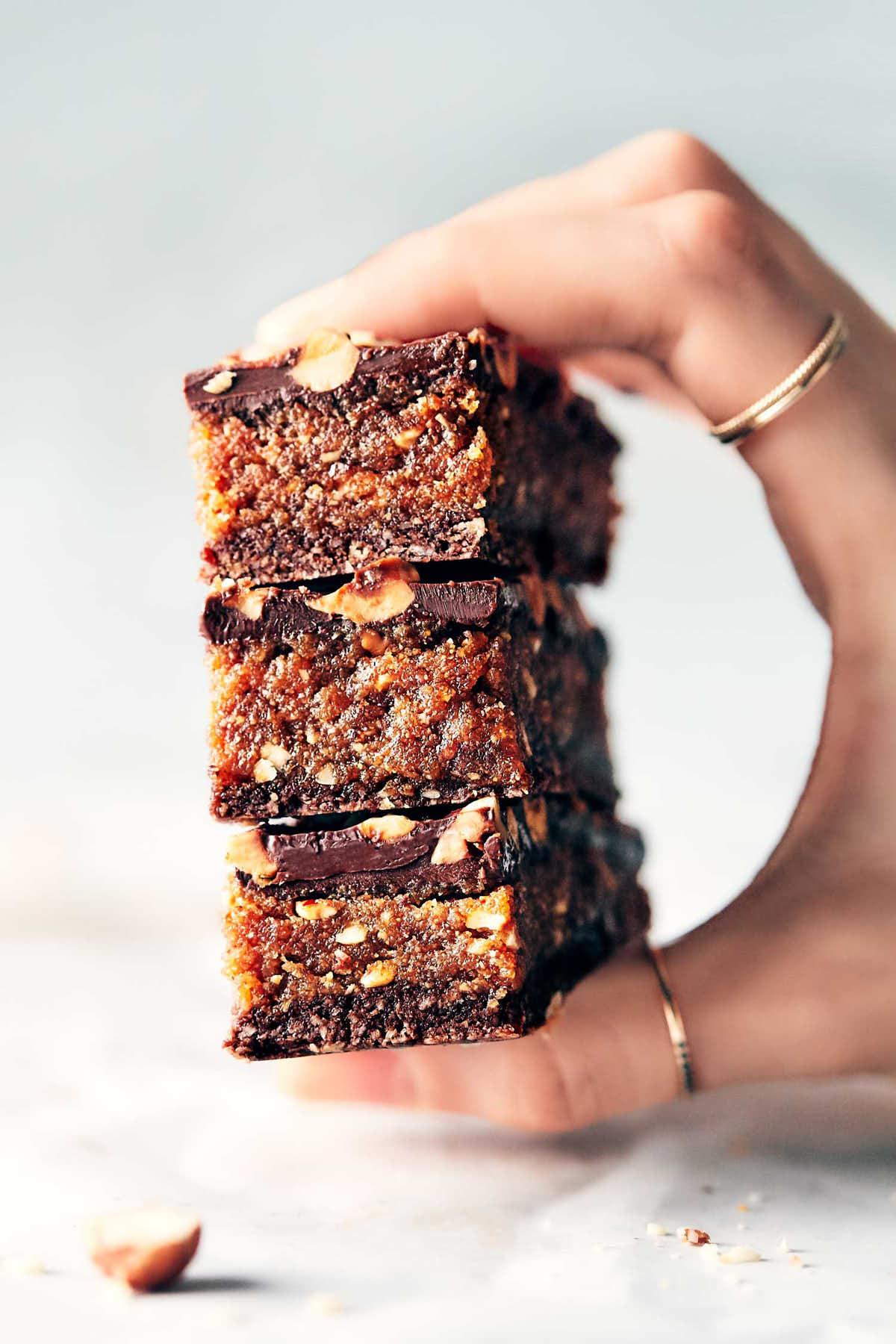Close-up of a slice of hazelnut rhubarb chocolate bar being lifted from a batch
