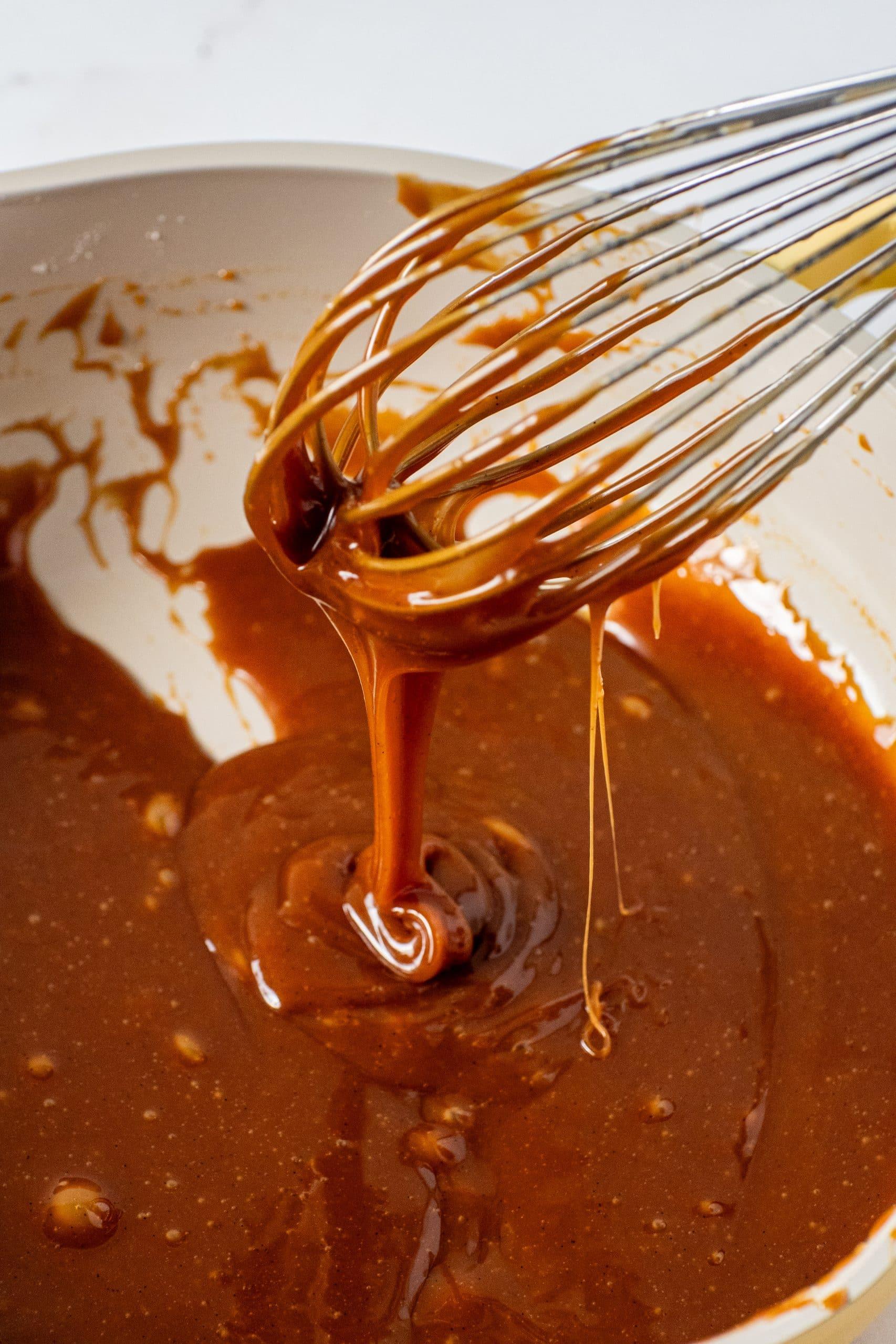 Close-up of salted caramel hot chocolate being swirled with a spoon, showing the rich texture