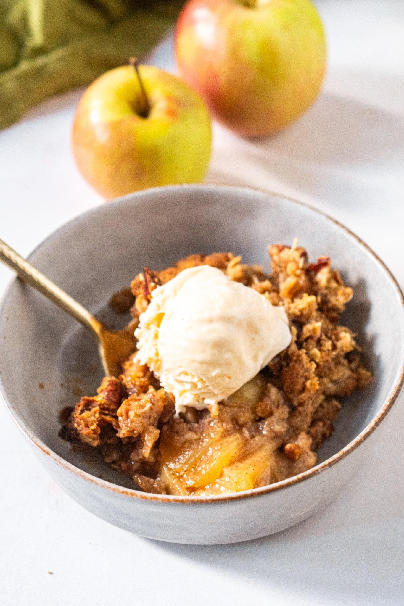 scoop of oatmeal apple crisp being served with vanilla ice cream