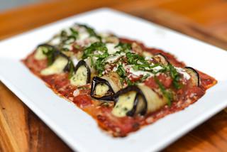 Ingredients for grilled eggplant rollatini laid out on a wooden surface