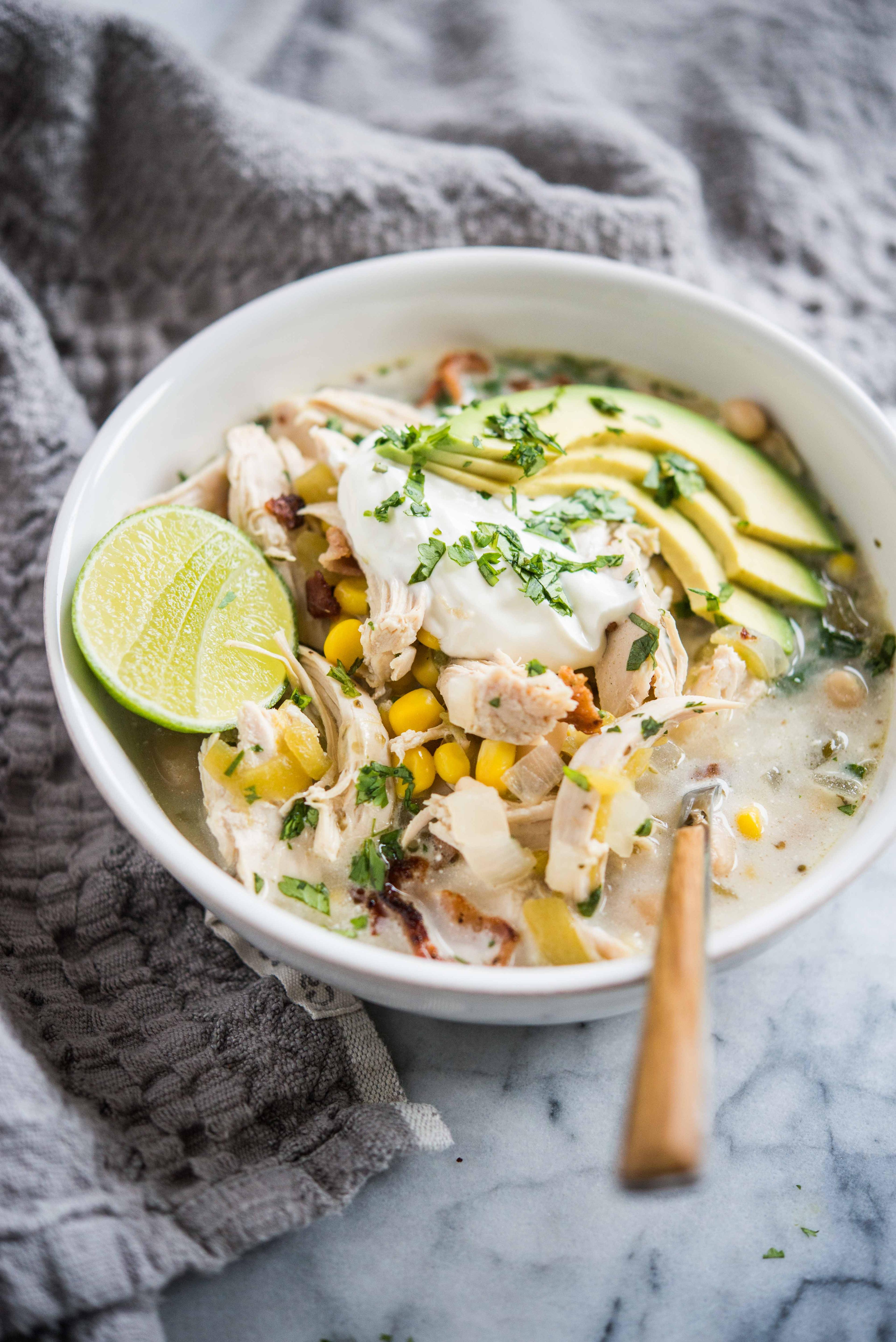 bowl of creamy white chicken chili topped with cilantro and sour cream