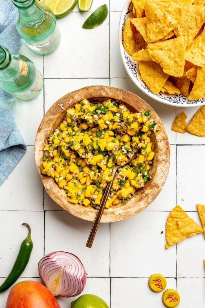 overhead shot of mango salsa nachos supreme on a wooden board
