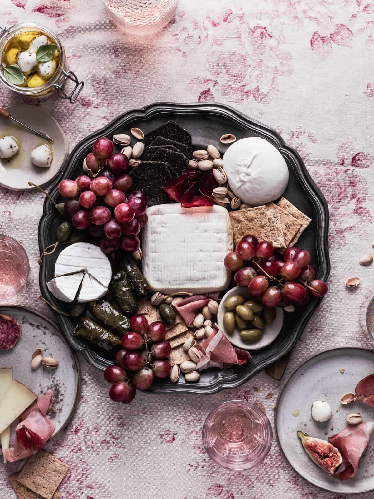 Overhead view of a beautifully arranged Mediterranean charcuterie board on a rustic wooden table