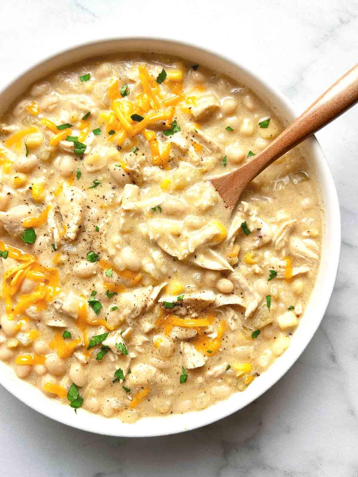 Close-up of creamy white chicken chili being stirred in a pot