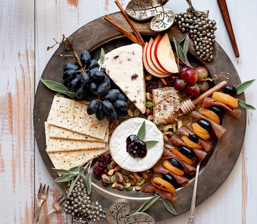 Overhead shot of a beautifully arranged smoked cheese board with various cheeses, fruits, and nuts