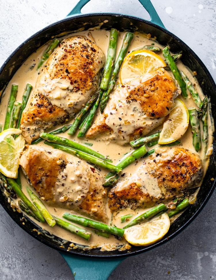 lemon butter chicken breast served with roasted asparagus and a small bowl of rice, beautifully plated