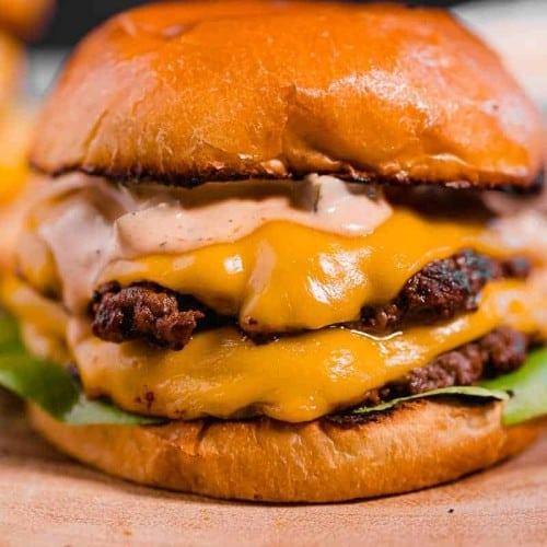 Close-up of a sizzling smash burger patty on a hot cast iron skillet