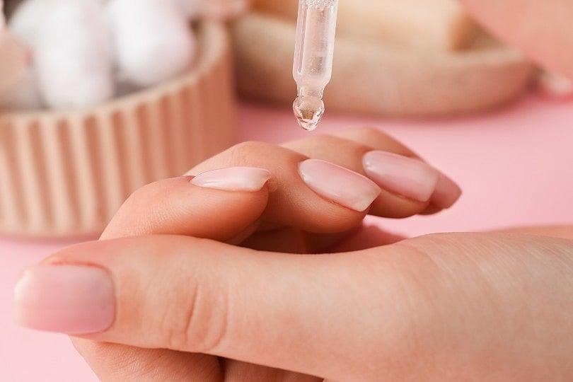 woman applying cuticle oil and moisturizer