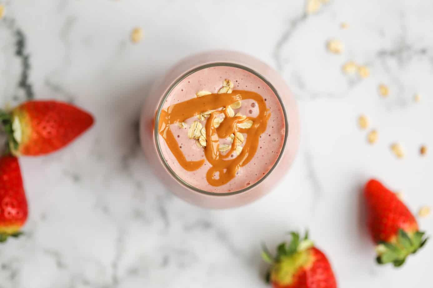a close-up shot of a vibrant golden strawberry banana smoothie in a glass