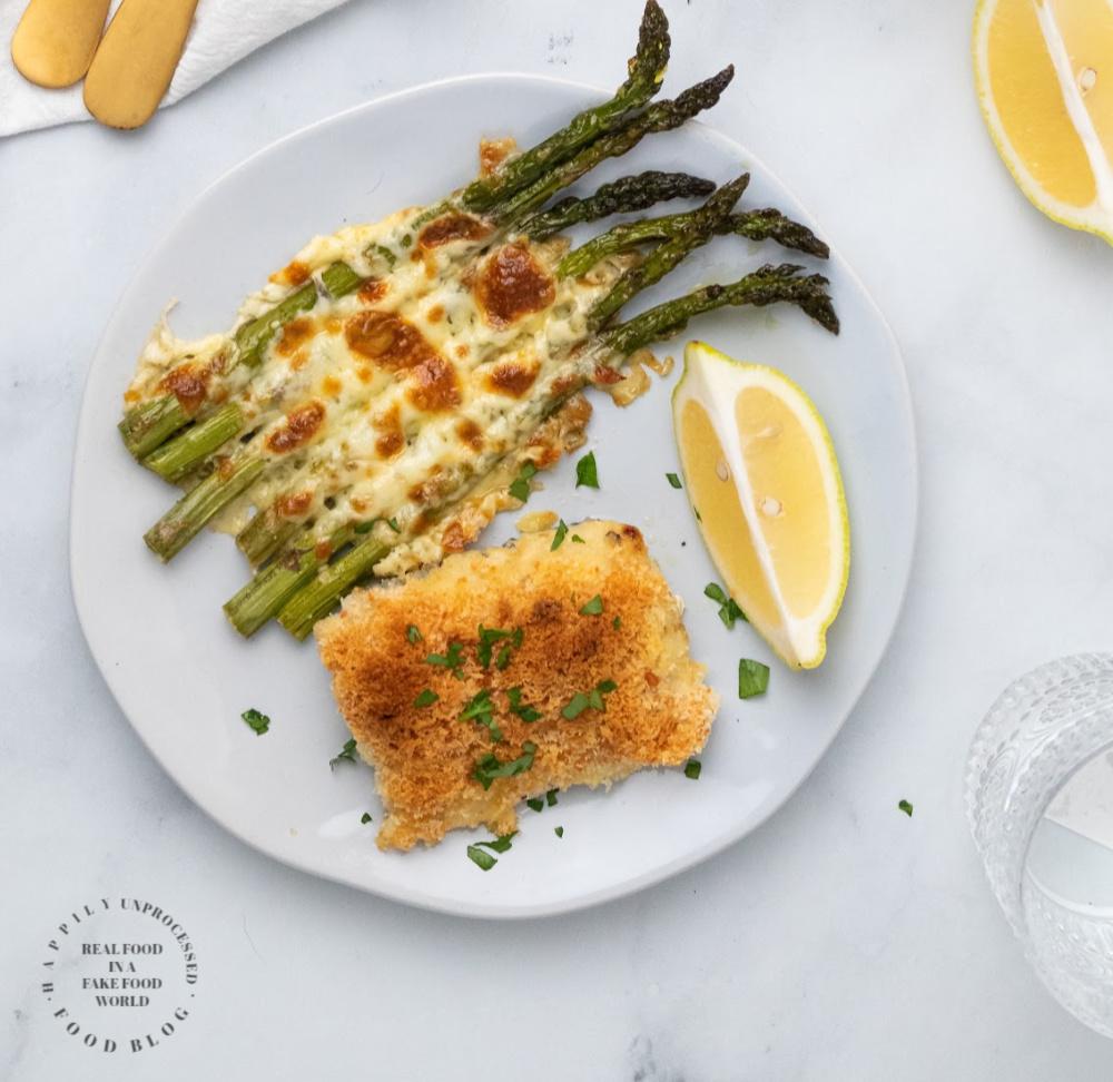 overhead shot of baked cod with golden brown edges, served with roasted asparagus