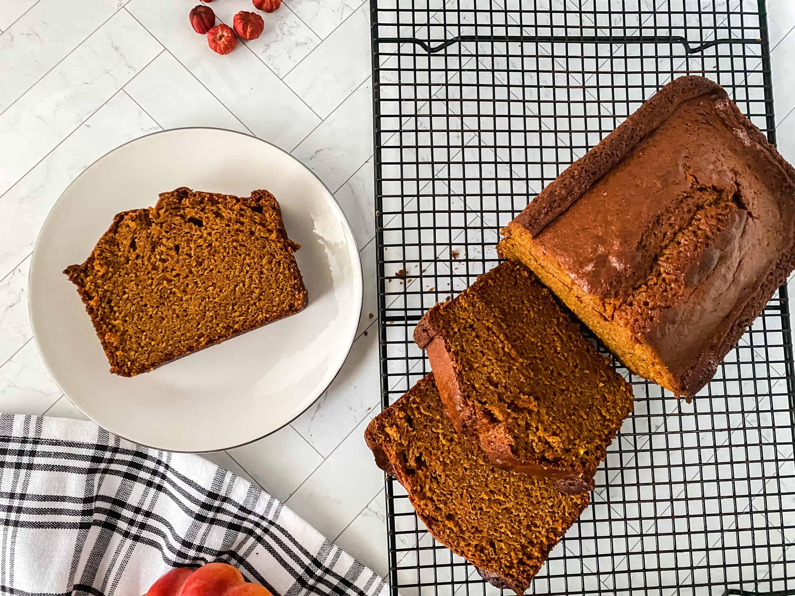 pumpkin bread loaf cooling on a wire rack in a cozy kitchen setting