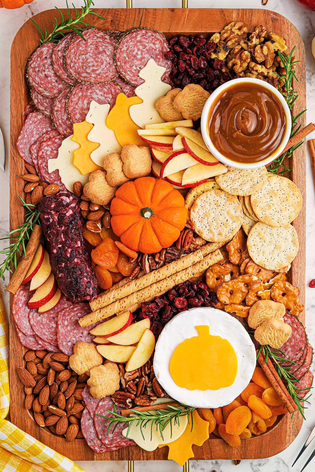 close-up of various cheeses, meats, fruits, and nuts arranged on a charcuterie board, showcasing different textures and colors