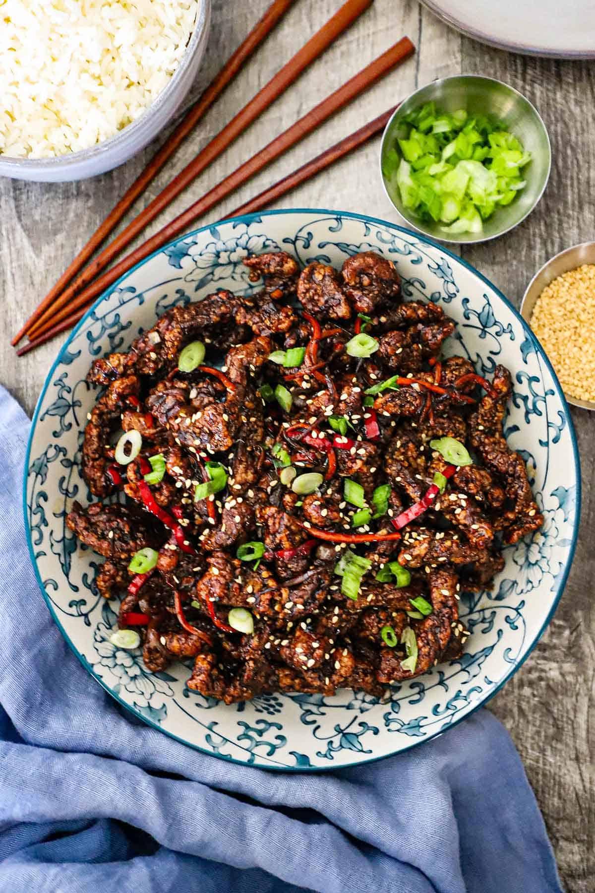 overhead shot of two chili-glazed beef bowls with chopsticks