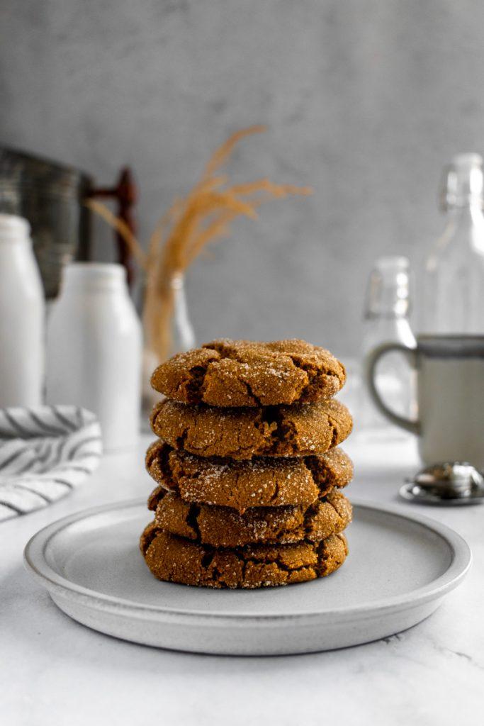 Plate of crinkly dark molasses cookies with a glass of milk, cozy kitchen autumn