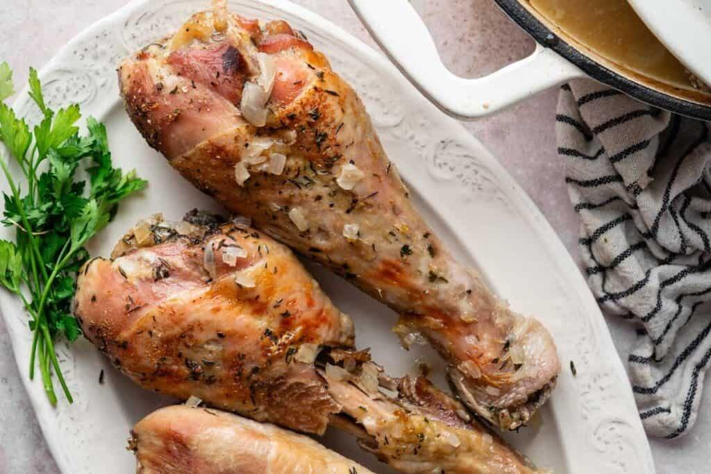 Close-up of a perfectly roasted turkey leg with herbs, glistening skin