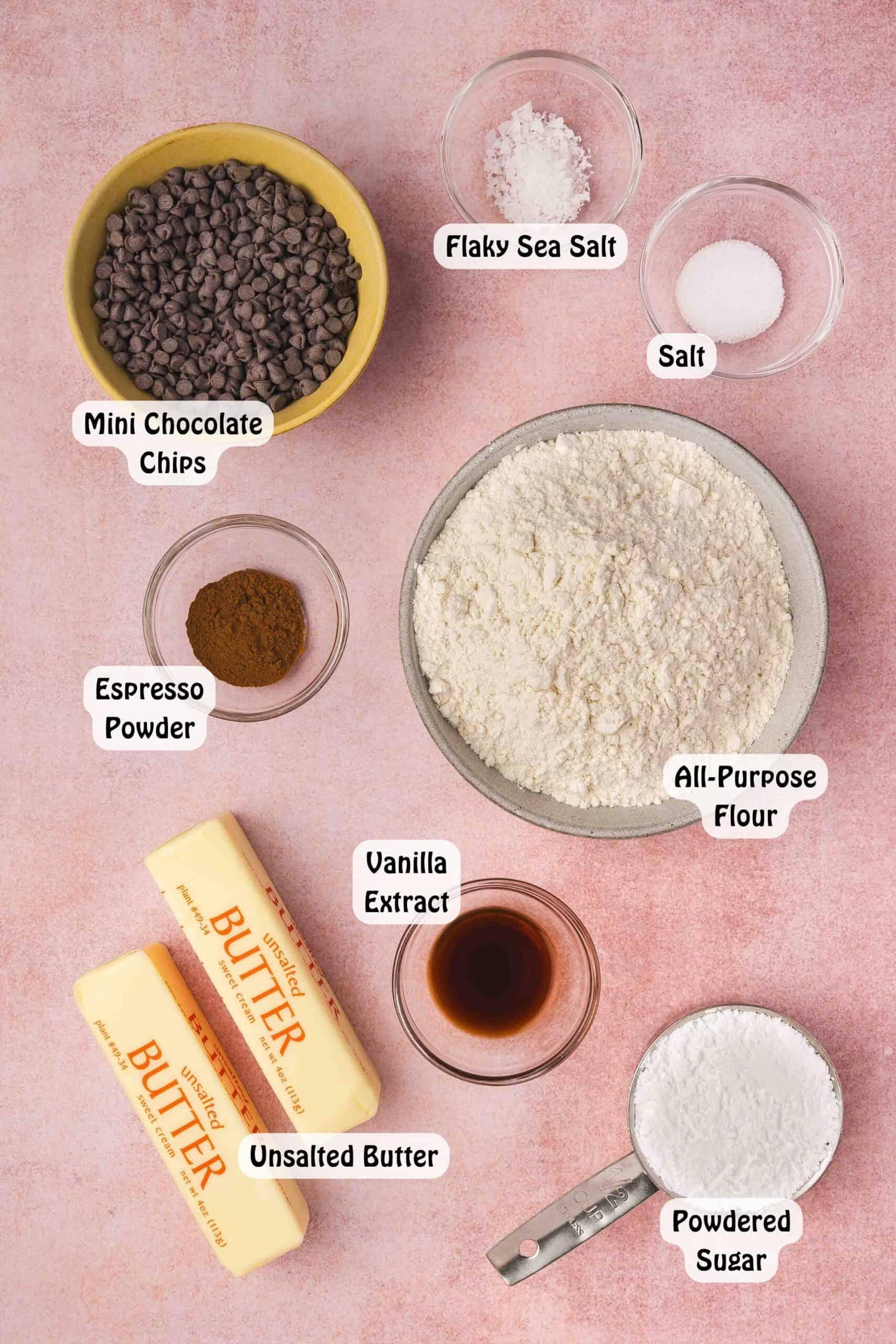 ingredients for espresso shortbread cookies laid out on a kitchen counter: butter, flour, sugar, espresso powder, vanilla extract