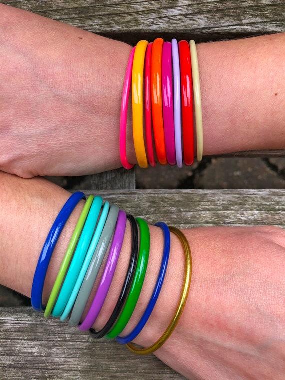 stack of colorful enamel bangles on a wrist