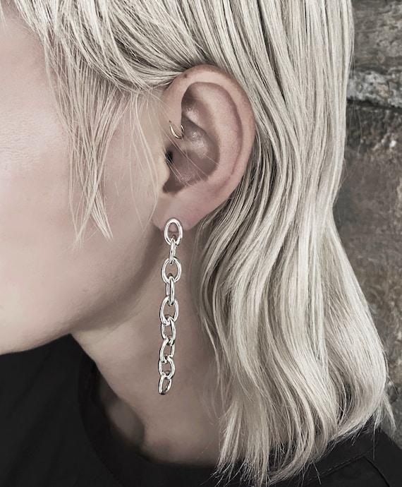woman carefully cleaning her chunky chain earrings