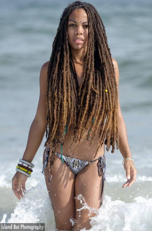 woman with short dreads smiling at the beach