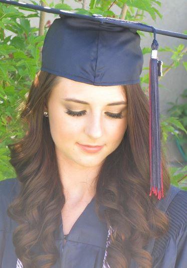 woman with simple makeup and hairstyle wearing a bright graduation dress