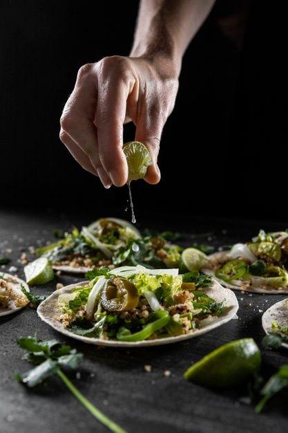 Close-up of someone squeezing lime juice onto a cabeza taco