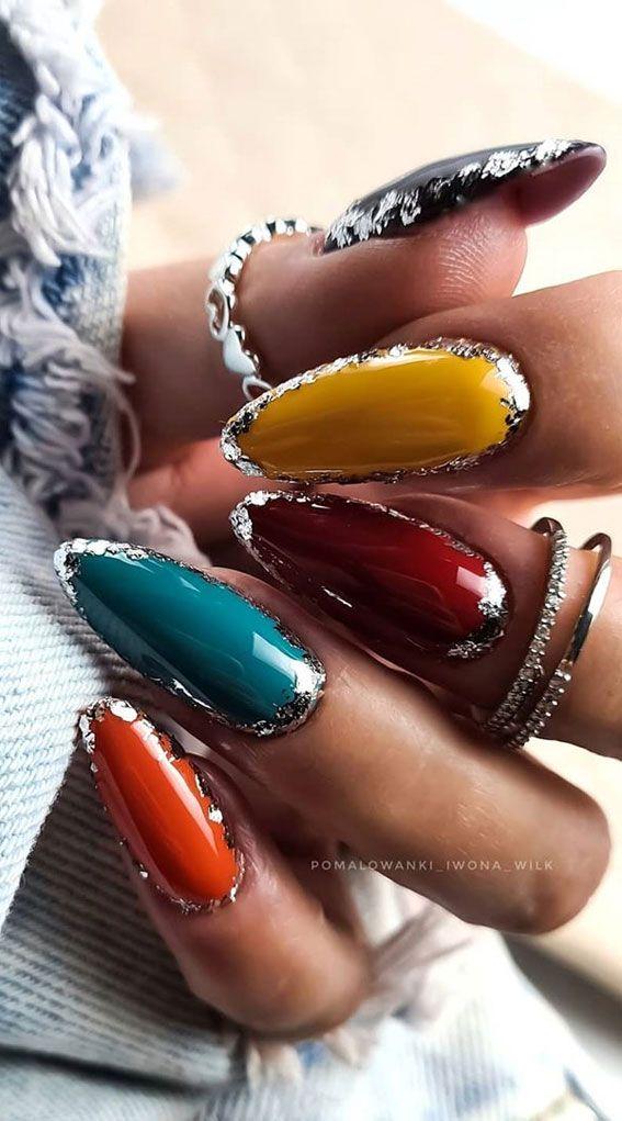 close up shot of jewel-toned autumn nail art with metallic accents