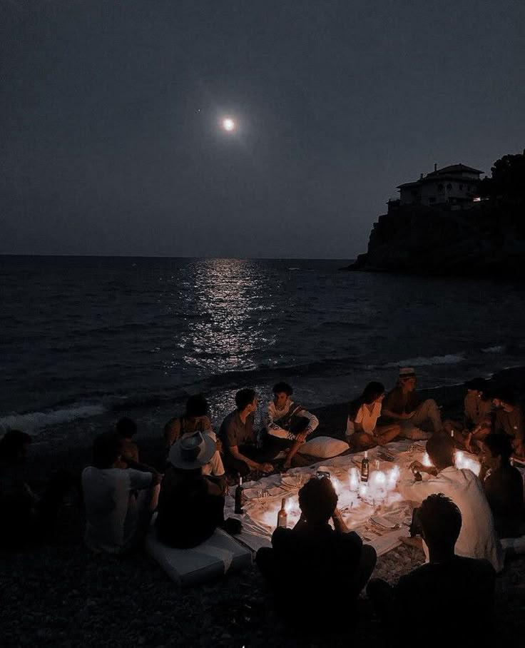group of friends on a beach at night