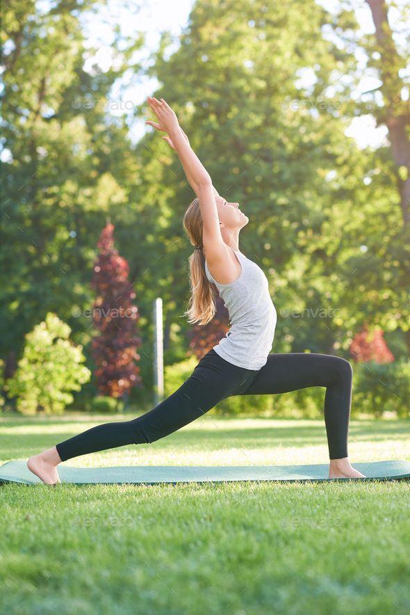 a woman doing yoga in a park