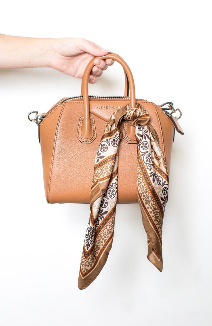 woman tying scarf around handbag handle