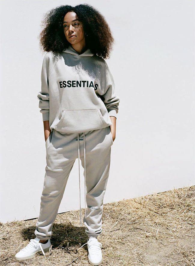 woman confidently styling a Fear of God outfit with Essentials pieces