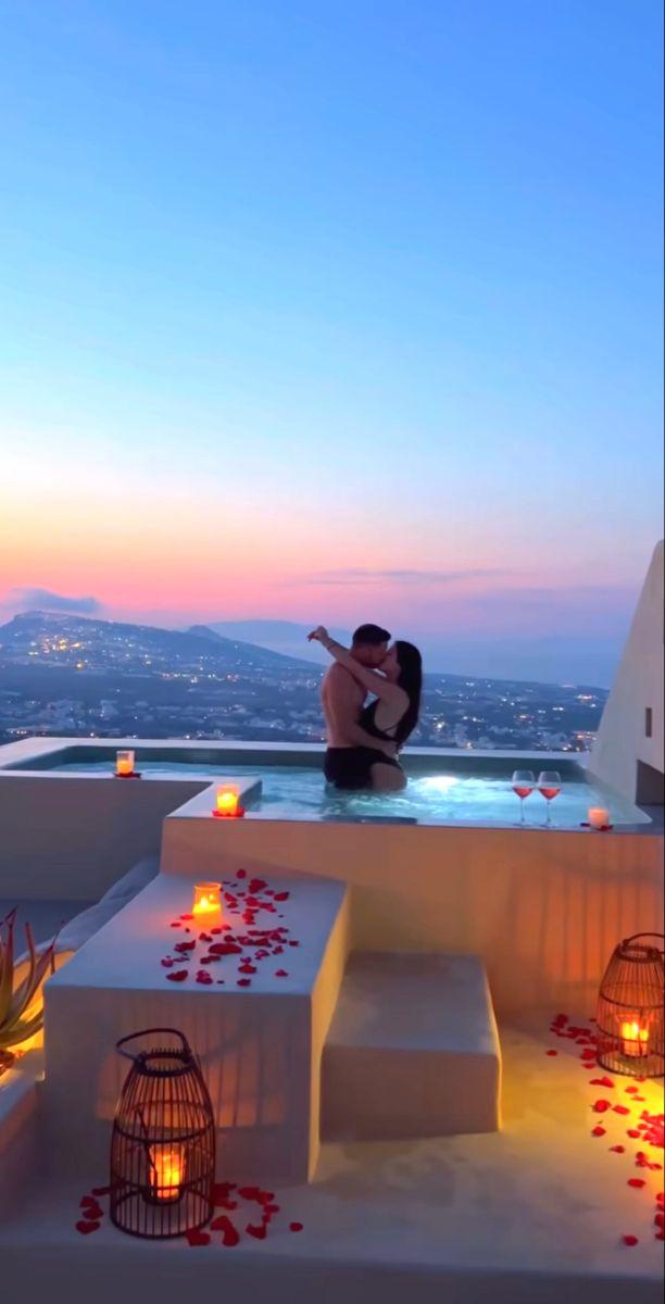 couple kissing on a Santorini balcony at sunset