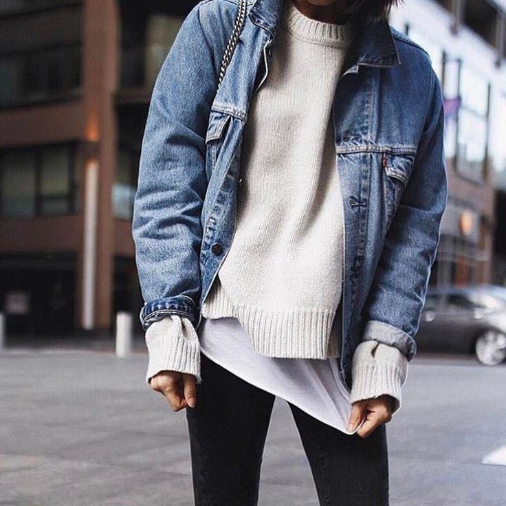 woman layering denim jacket over sweater