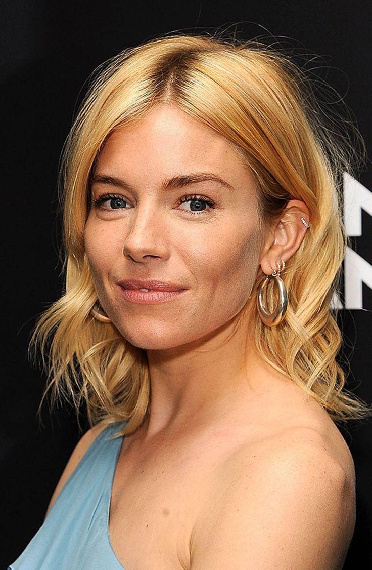 woman with multiple ear piercings smiling