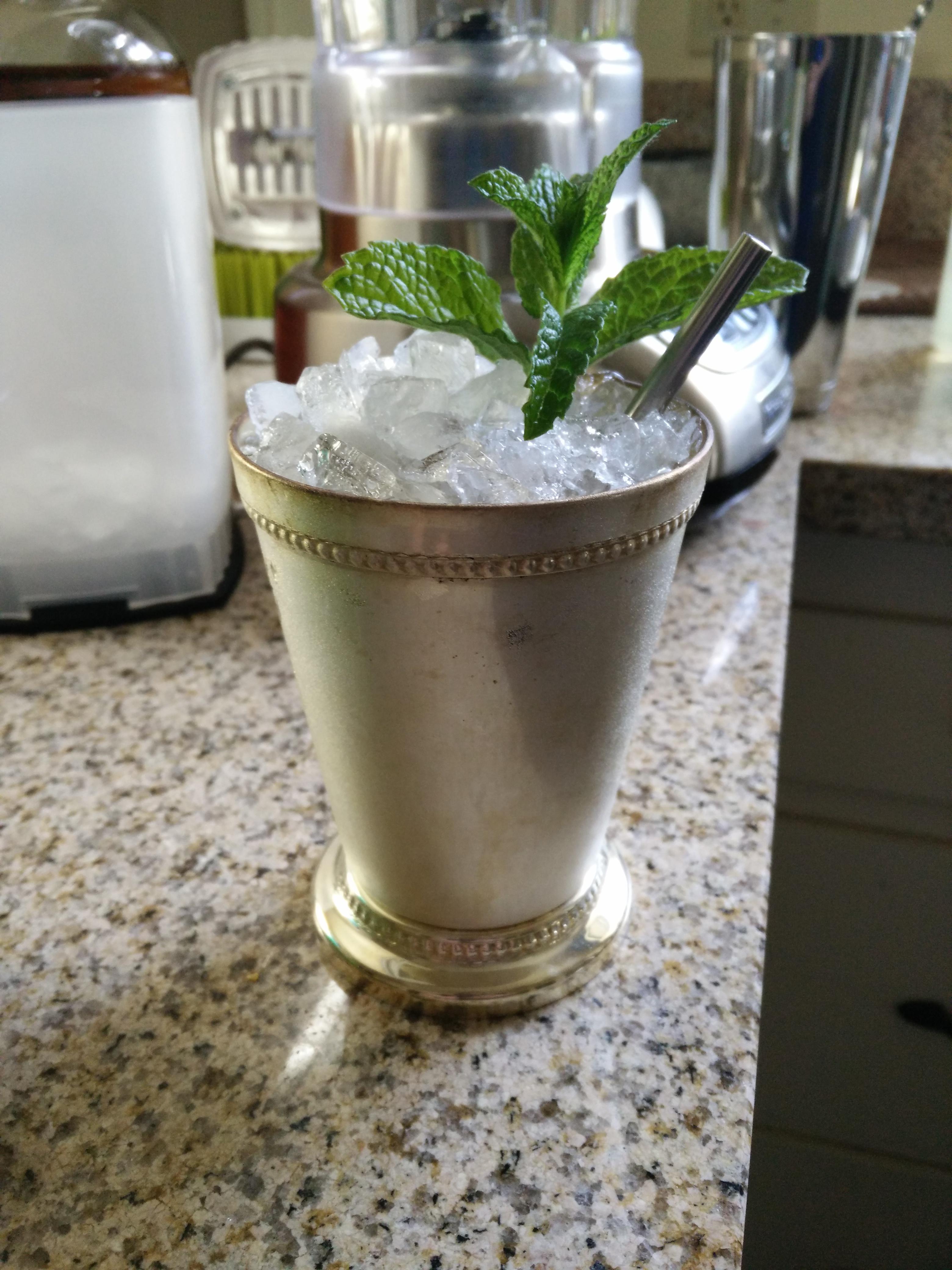 a close-up of muddled mint leaves in a blender