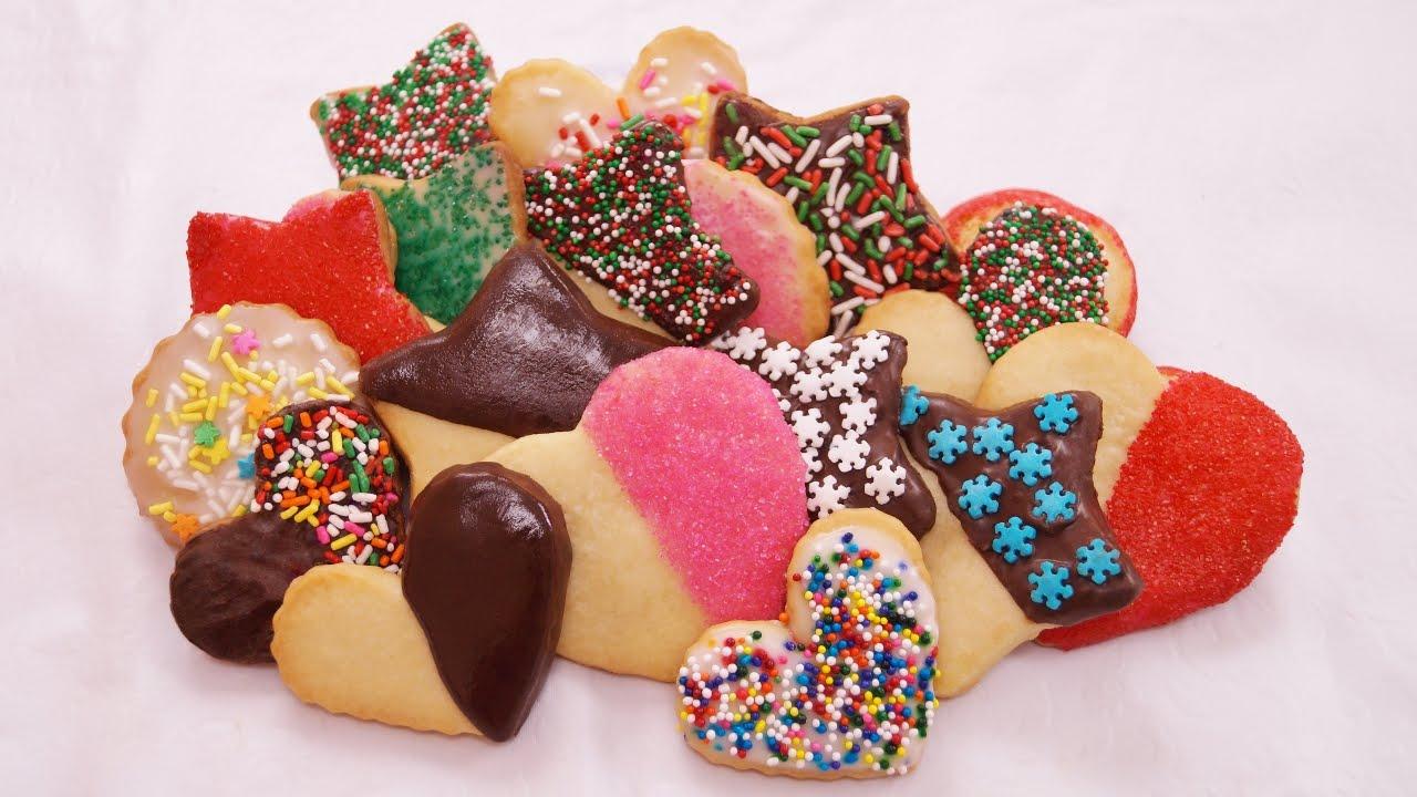 hands decorating shortbread cookies with colorful royal icing, artistic focus
