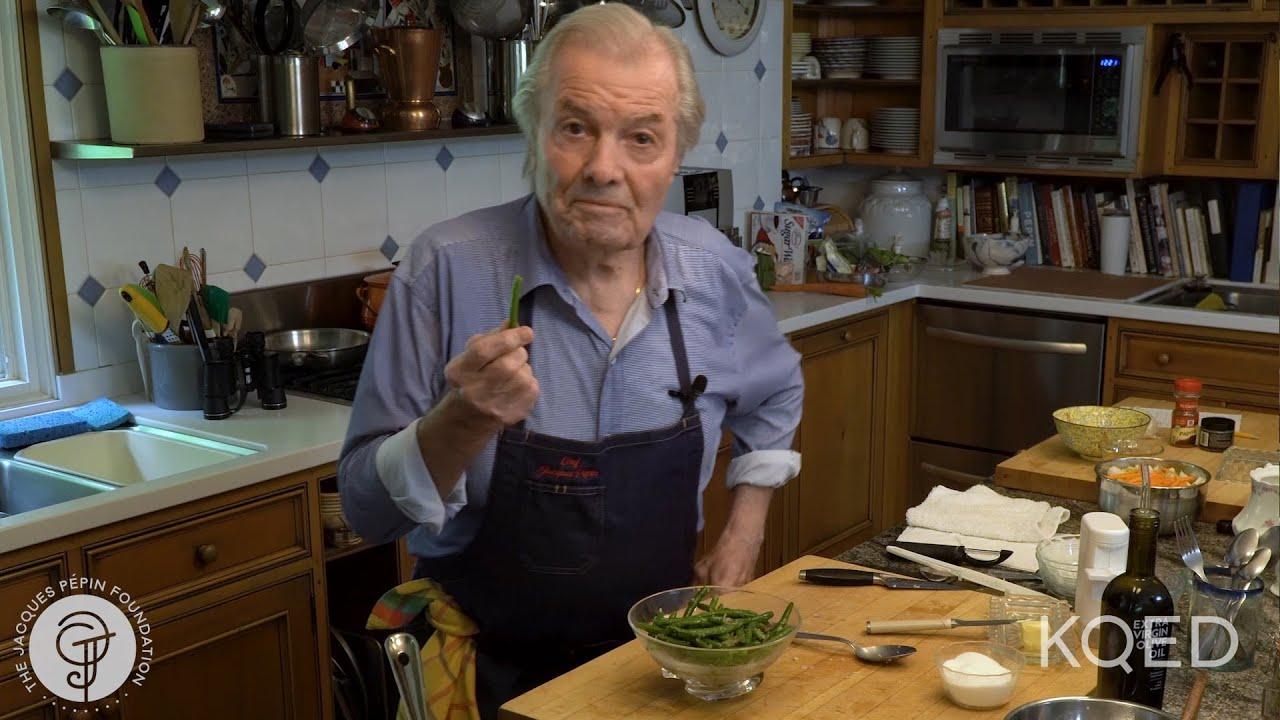 chef preparing fresh green beans and shallots on a wooden cutting board with a sense of excitement