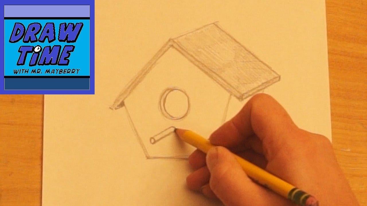 person sketching a birdhouse design on paper