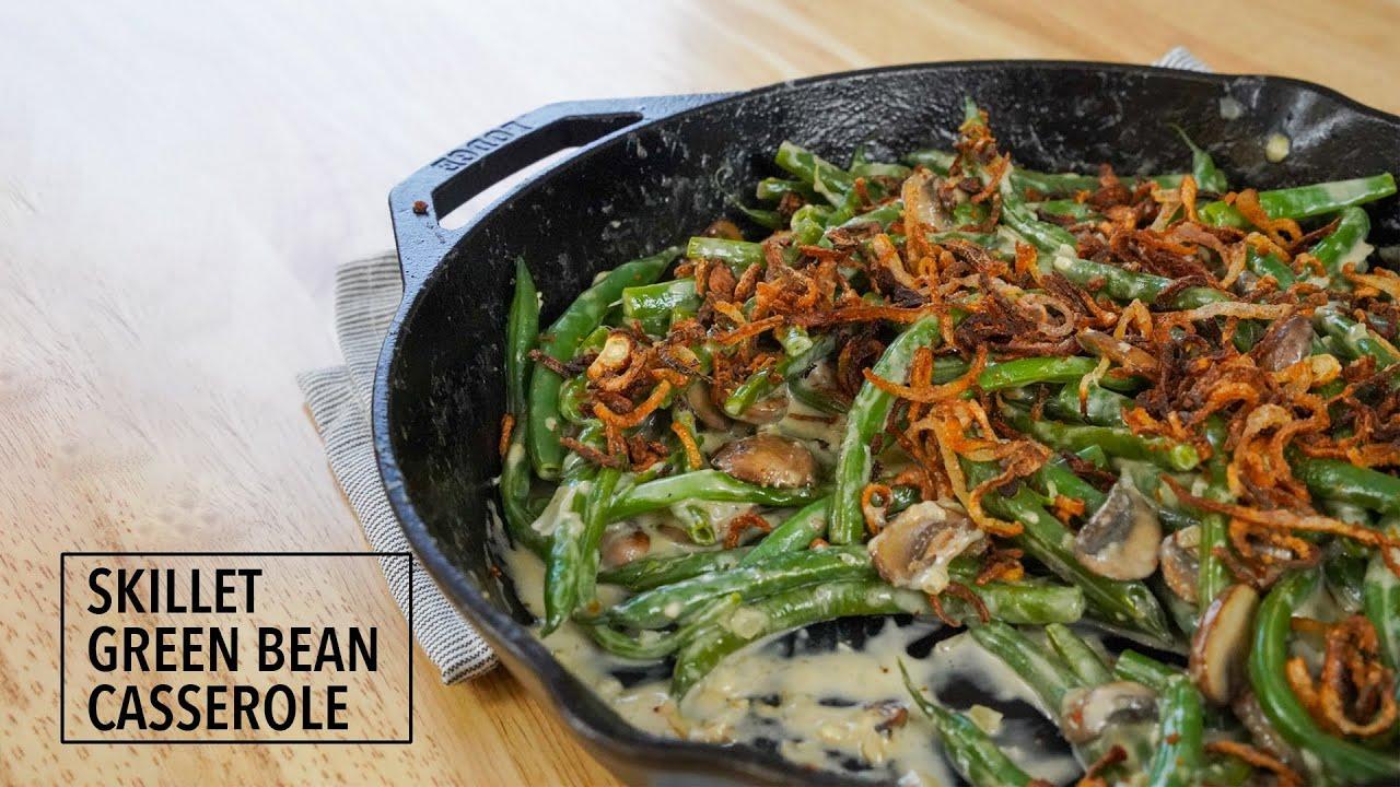 Skillet green bean casserole served directly from the pan with a fresh herb garnish