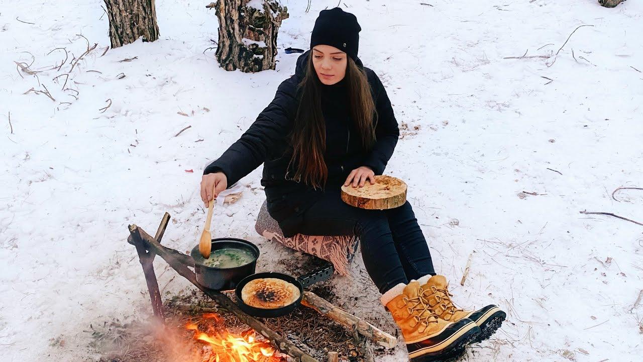 person cooking outdoors in winter