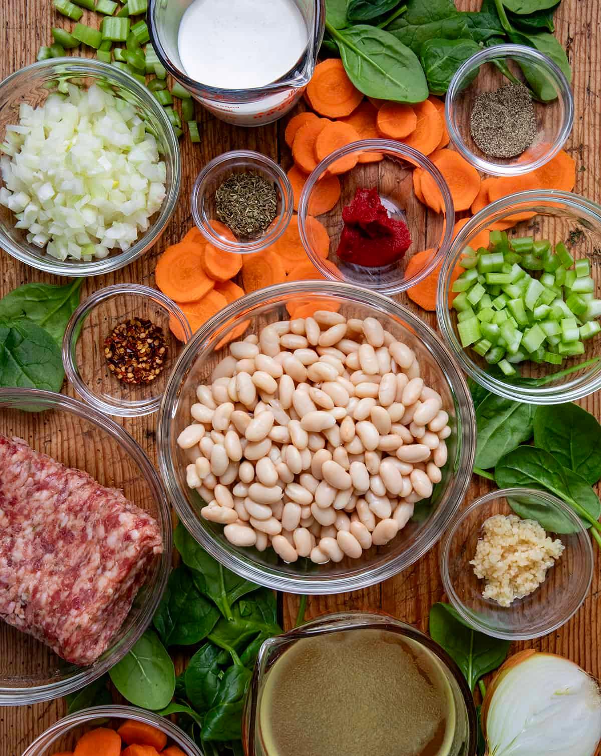 ingredients for Tuscan white bean soup laid out on a wooden table