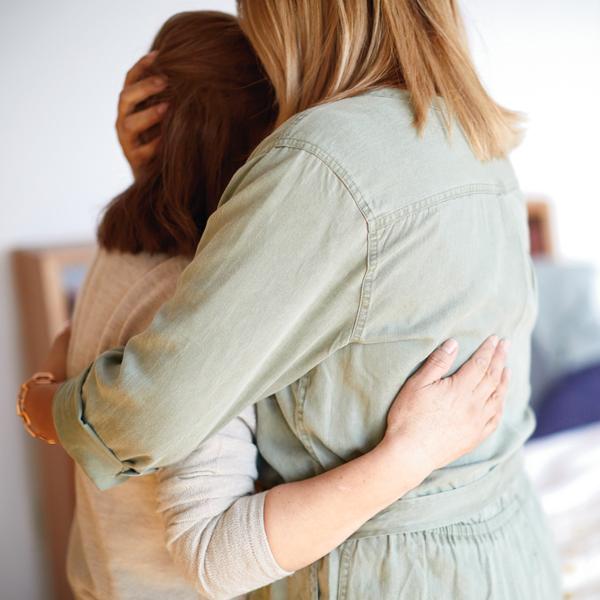 woman supporting a friend through a tough time, comforting hug