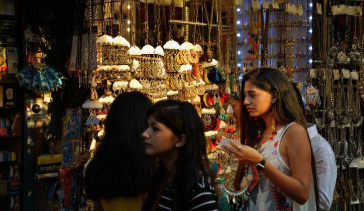woman shopping for earrings at a local market