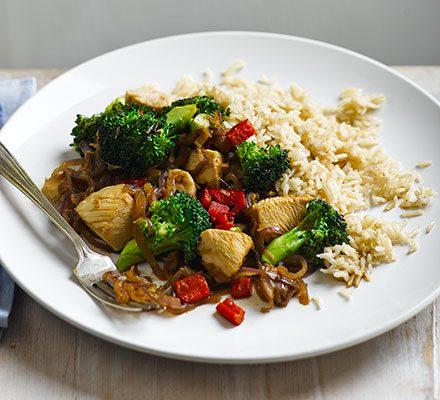 chicken and veggie stir-fry with brown rice in a wok
