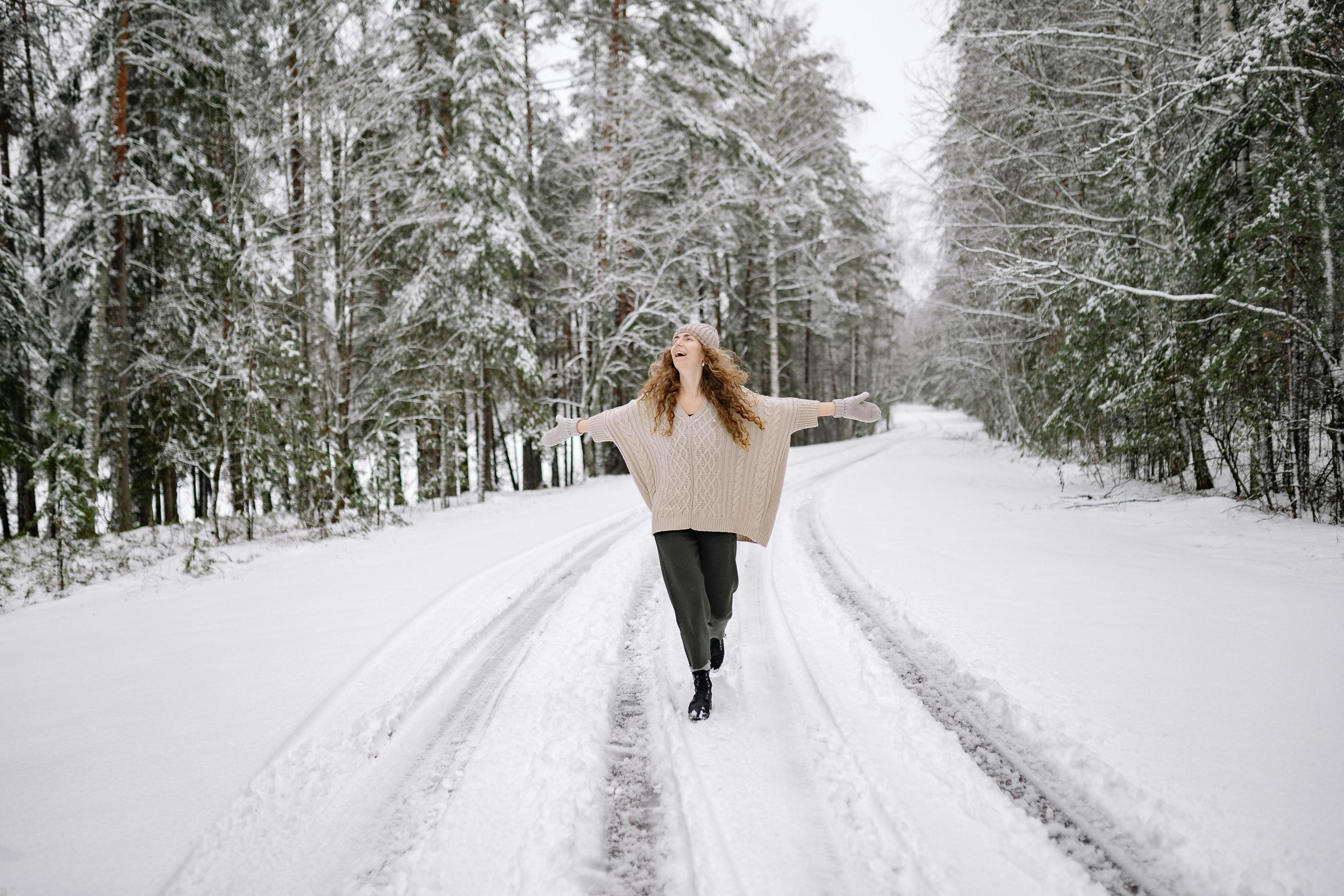 woman with beautiful winter braids walking in snowy park