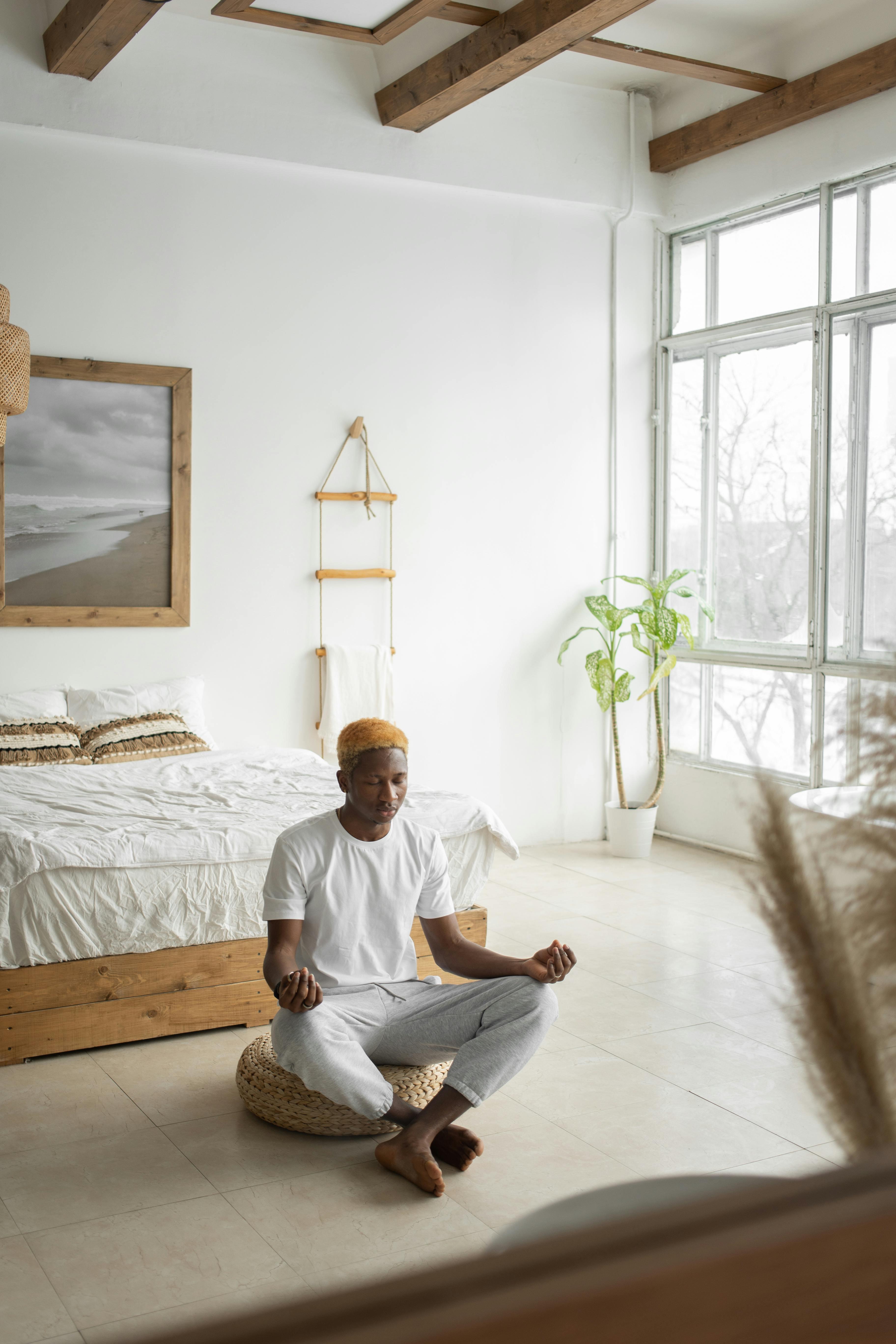 person meditating in a minimalist bedroom